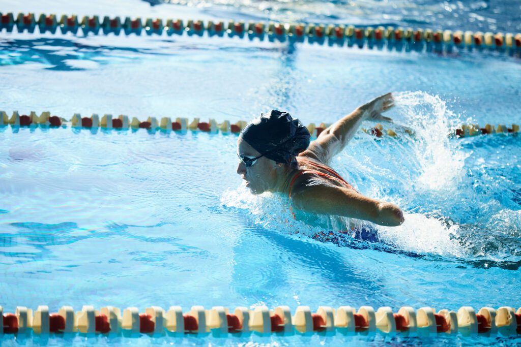 Adaptive athlete with a limb difference swimming using the butterfly stroke.