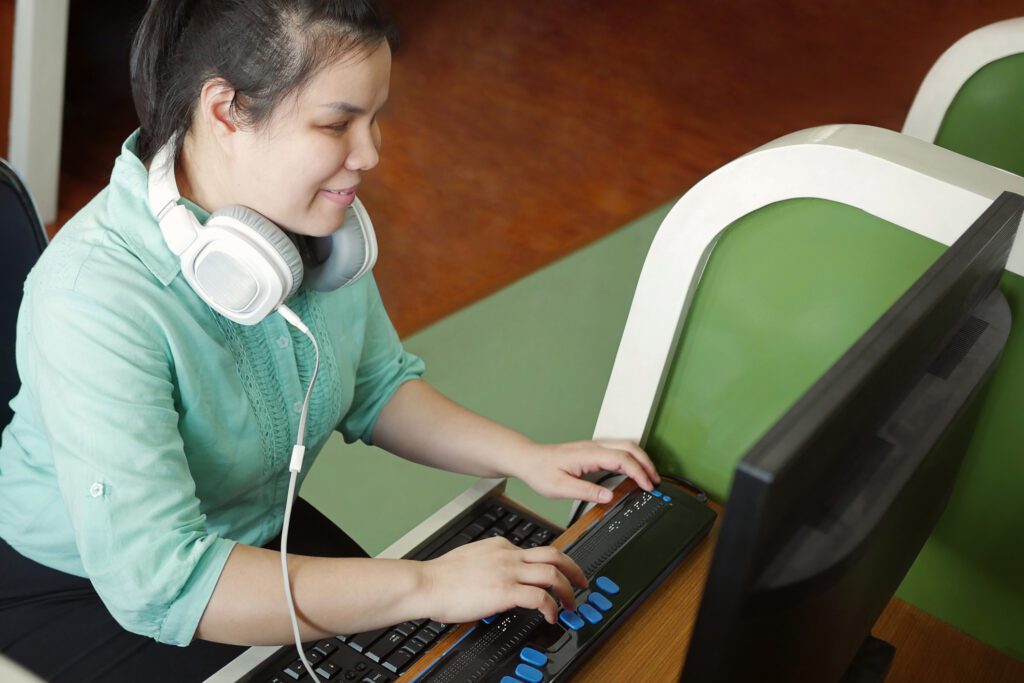 Young woman using assistive software oon her computer.