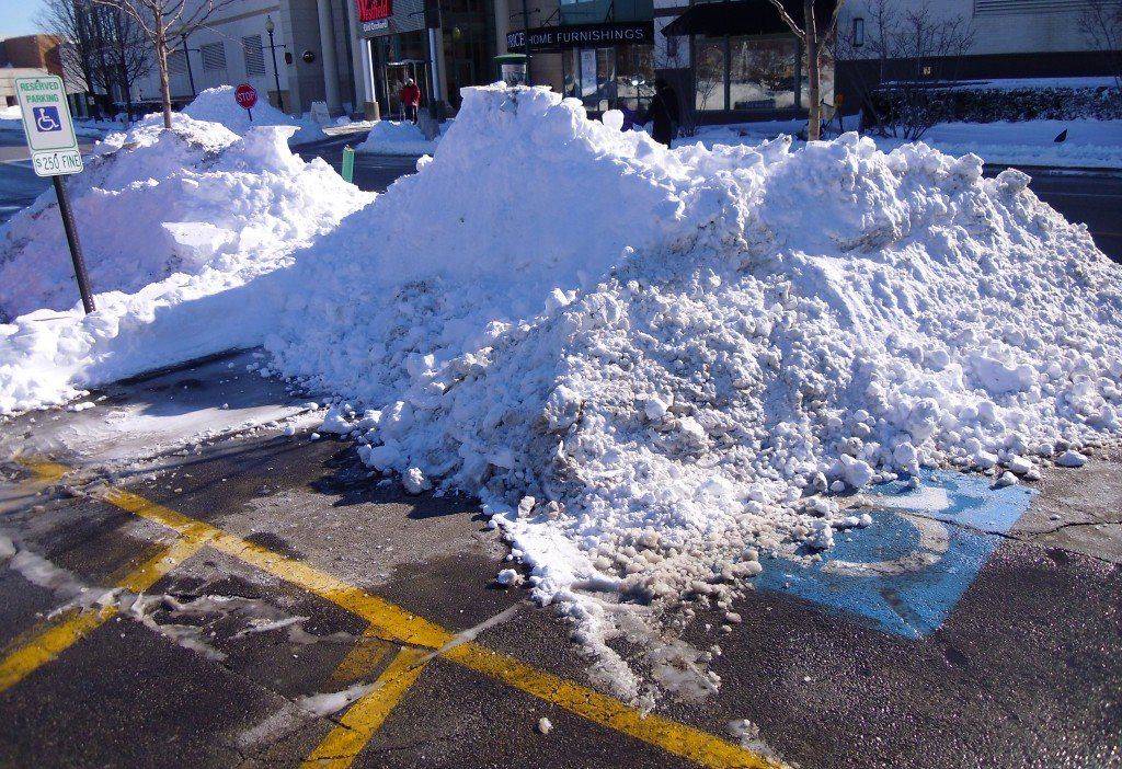 Shoveled snow piled into an accessible parking spot.