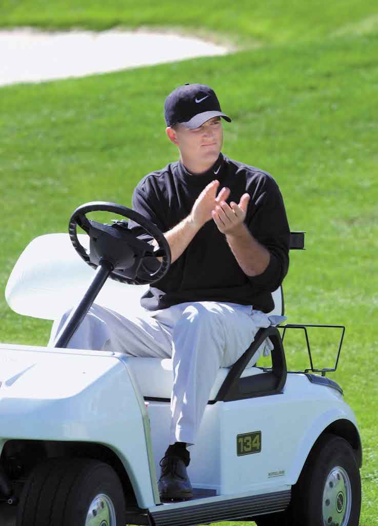 Casey Martin sitting in golf cart clapping during a golf tournament.